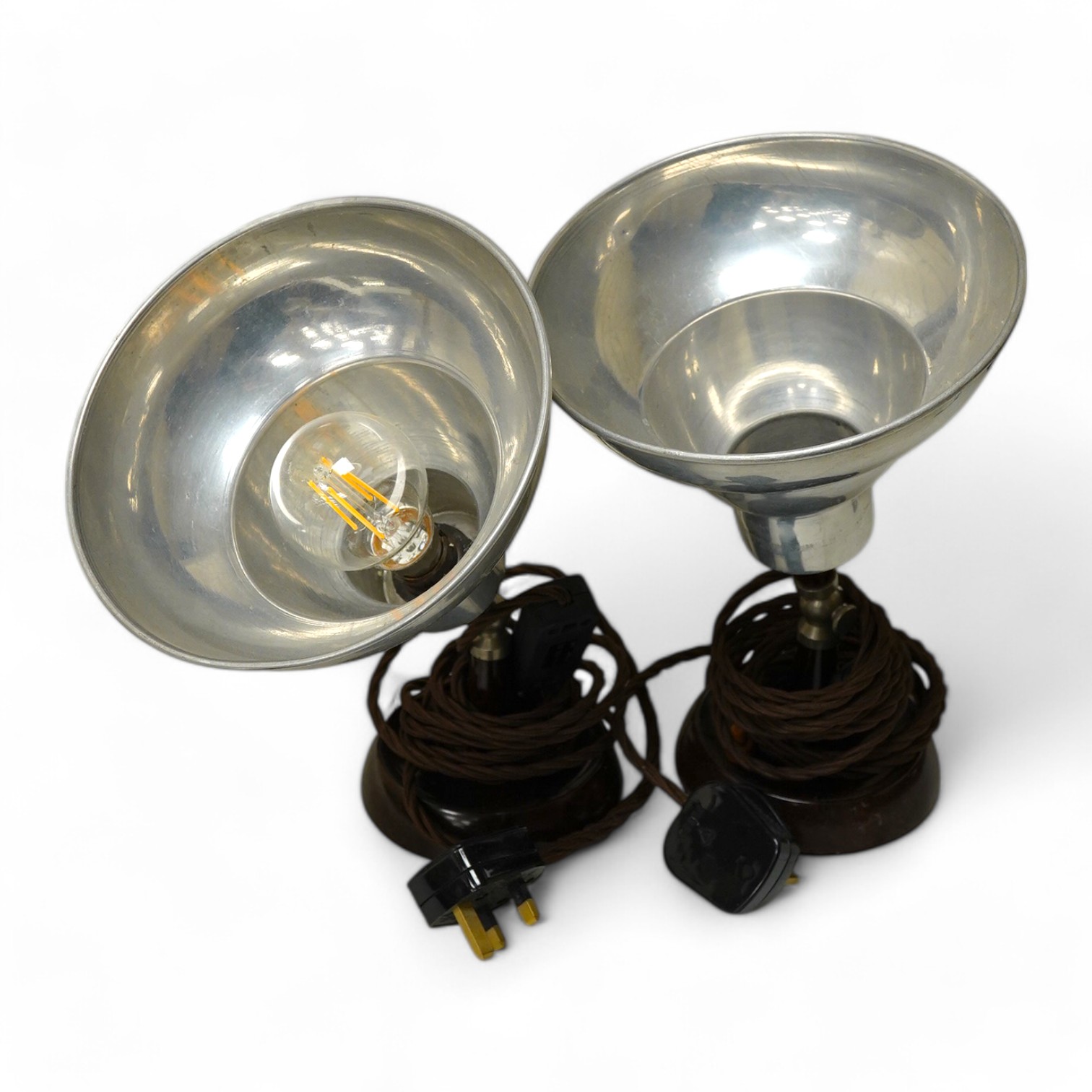 A pair of industrial-style photography aluminium shaded spot-lights on Bakelite stands, 29cm high. Condition - shades scratched from use, untested if working